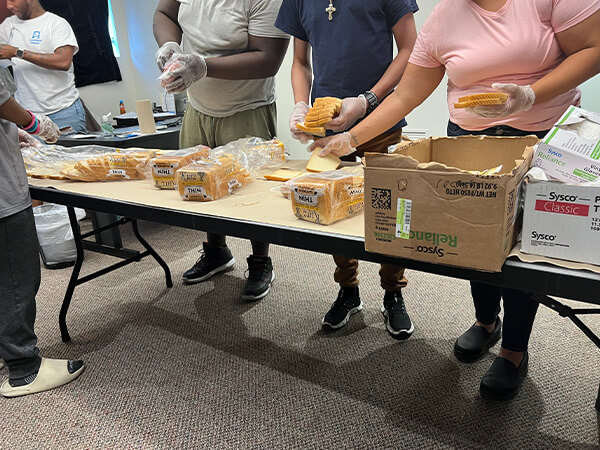 Covenant House Texas volunteers and youth making sandwiches for homeless kids