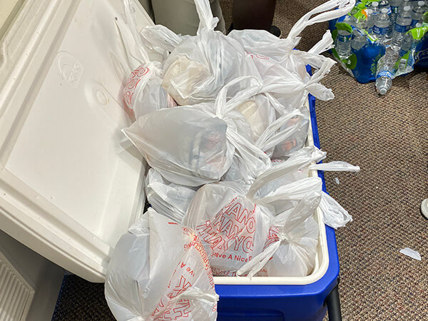 Cooler full of ice for sandwiches being made by volunteers at Covenant House Texas