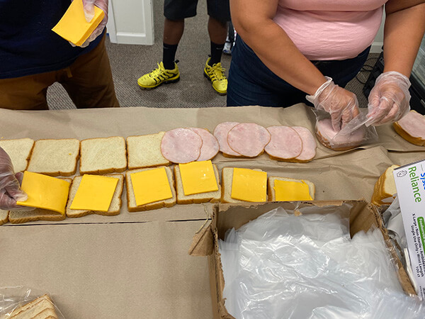 Covenant House youth and community volunteering to help put together sandwiches for homeless youth