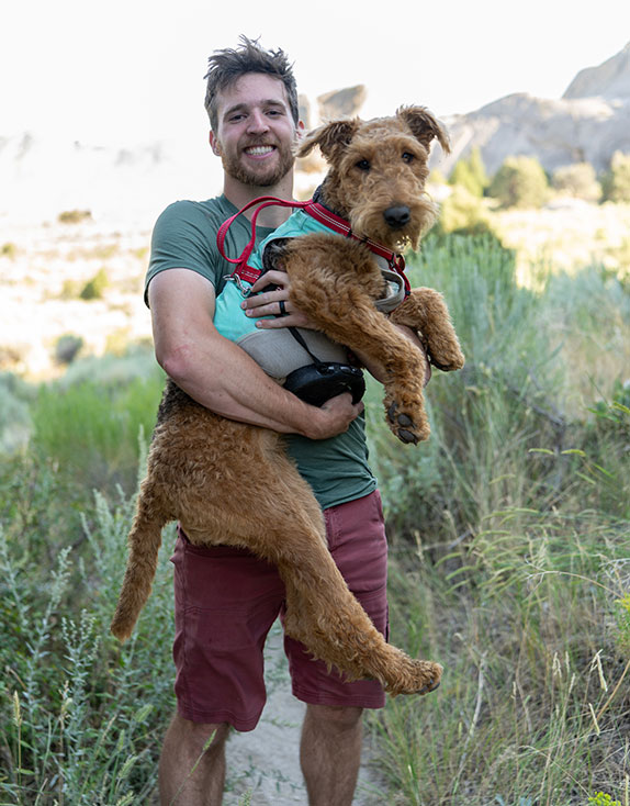 Covenant House Alaska Volunteer Jack carrying dog