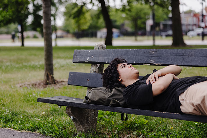 homeless teen sleeping outside on park bench | Covenant House