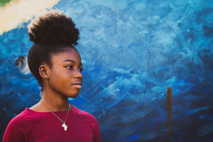 Former homeless teenage girl with mural backdrop