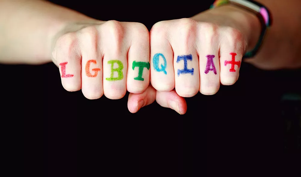 LGBTQ+ written across someone's hands | Covenant House LGBTQ+ homeless youth