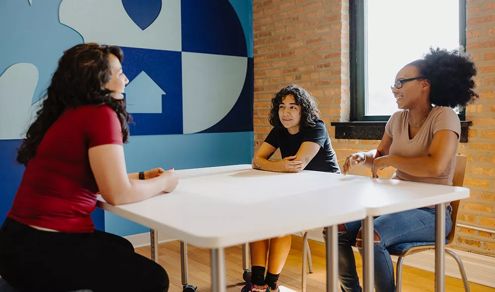 group of homeless youth talking at a table at Covenant House