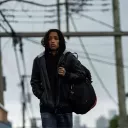 Young man walking outdoors with a backpack