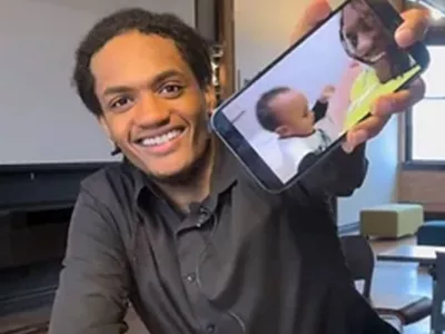 Zoereon holding phone displaying picture of son and mom