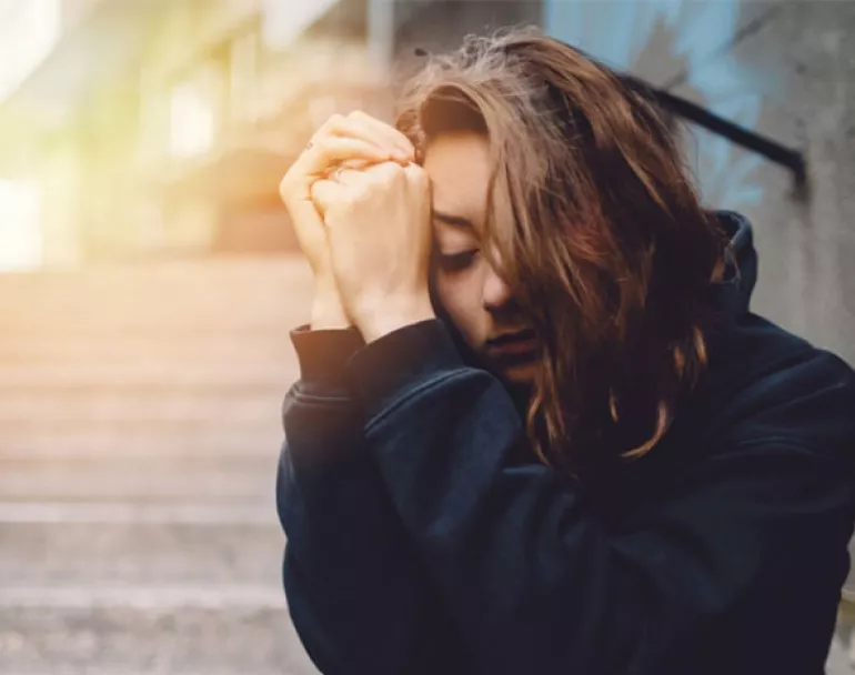 Sad homeless girl sitting on outdoor staircase | Covenant House - Donate Today