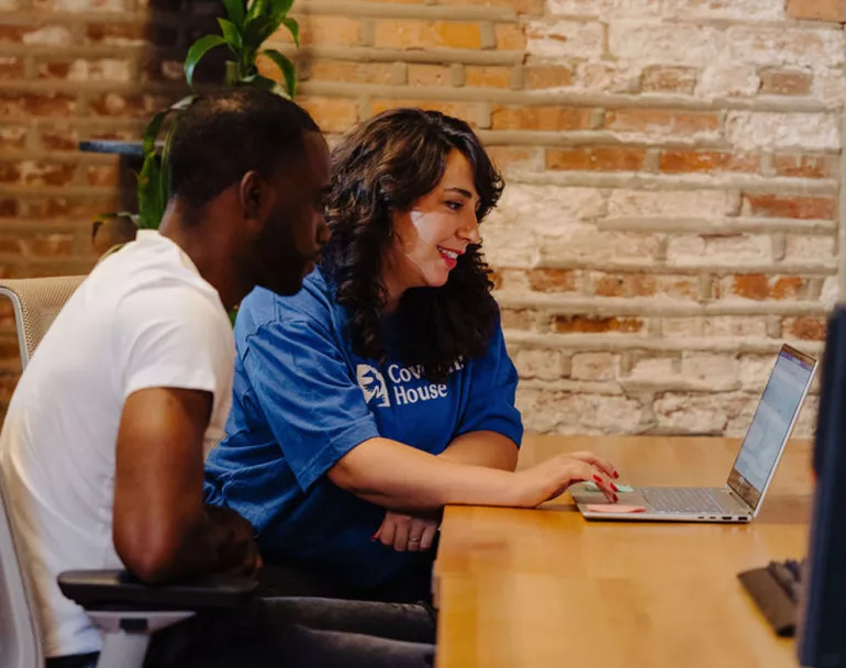 Covenant House staff and youth sitting together with laptop