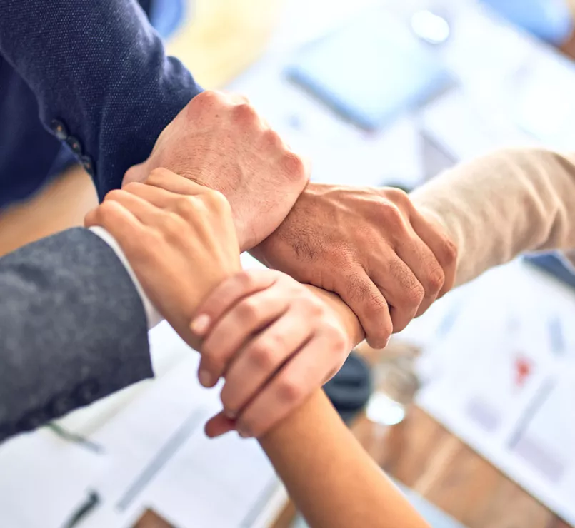 leaders holding each other's wrists symbolizing teamwork | Covenant House - Leadership